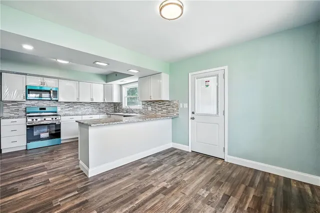 a kitchen with granite countertop a refrigerator and a sink