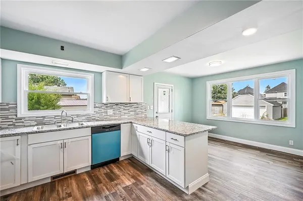 a view of a kitchen with kitchen island granite countertop a refrigerator and window