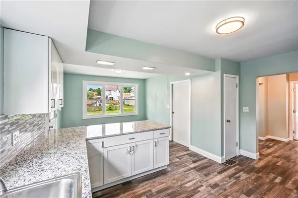 a kitchen with stainless steel appliances granite countertop a sink refrigerator and cabinets