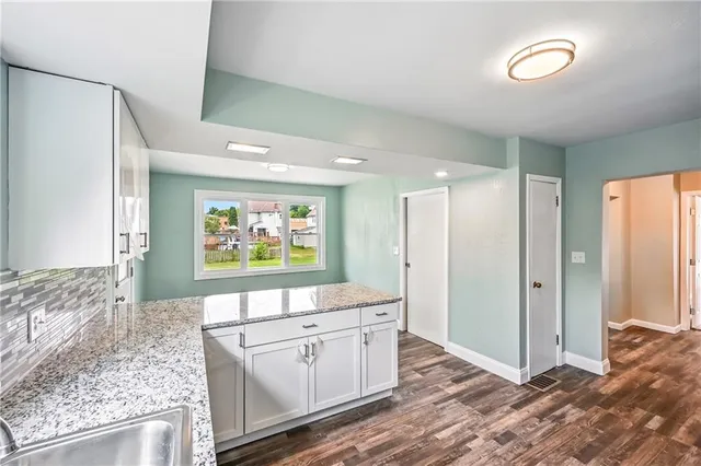 a kitchen with stainless steel appliances granite countertop a sink refrigerator and cabinets