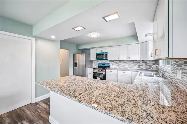 a kitchen with stainless steel appliances granite countertop a refrigerator sink and stove