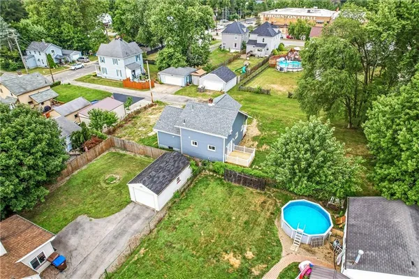 an aerial view of residential houses with outdoor space and trees