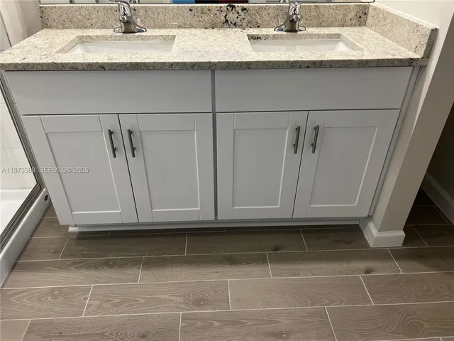 a bathroom with a granite countertop sink