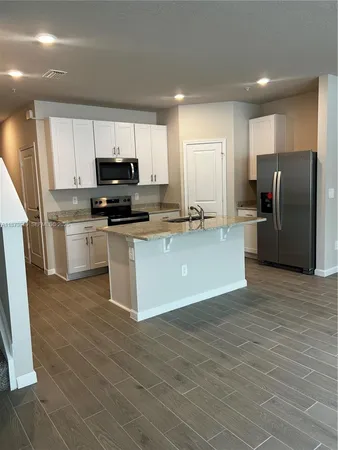 a kitchen with stainless steel appliances a refrigerator sink and microwave