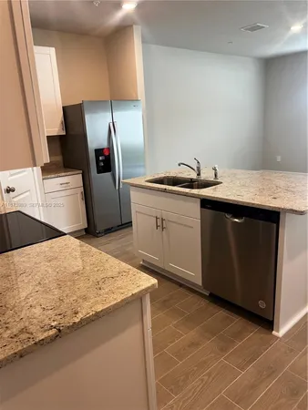 a kitchen with stainless steel appliances granite countertop a sink and a stove
