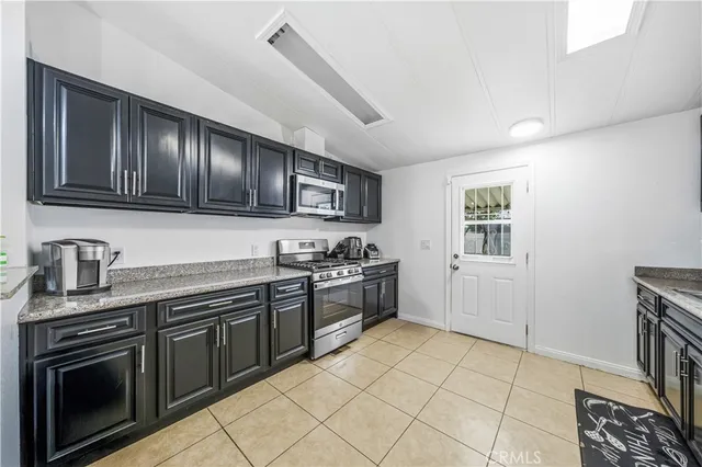 a kitchen with stainless steel appliances granite countertop a stove sink and cabinets