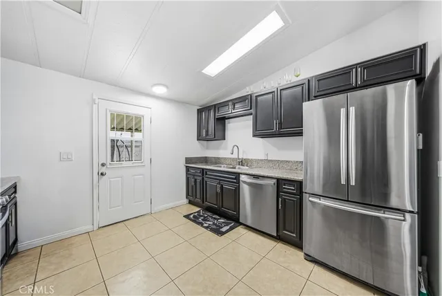 a kitchen with granite countertop a refrigerator and a stove top oven