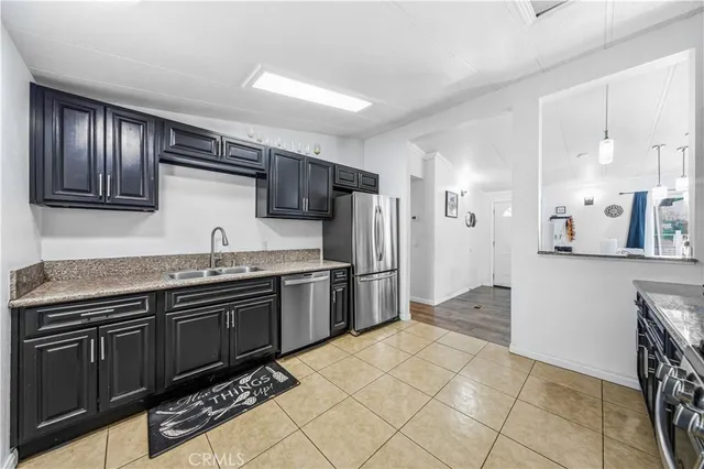 a kitchen with stainless steel appliances granite countertop a refrigerator and a stove top oven
