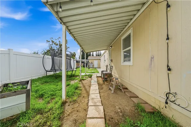 a backyard with table and chairs with potted plants