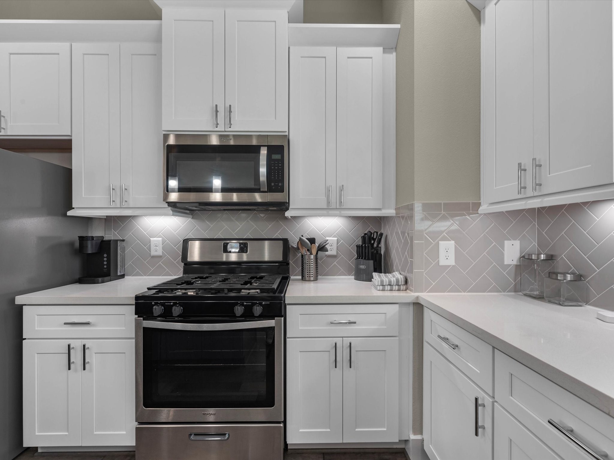 8311 Brecha Lane Houston, TX 77055 - Photo 5 of 19 a kitchen with white cabinets and black appliances
