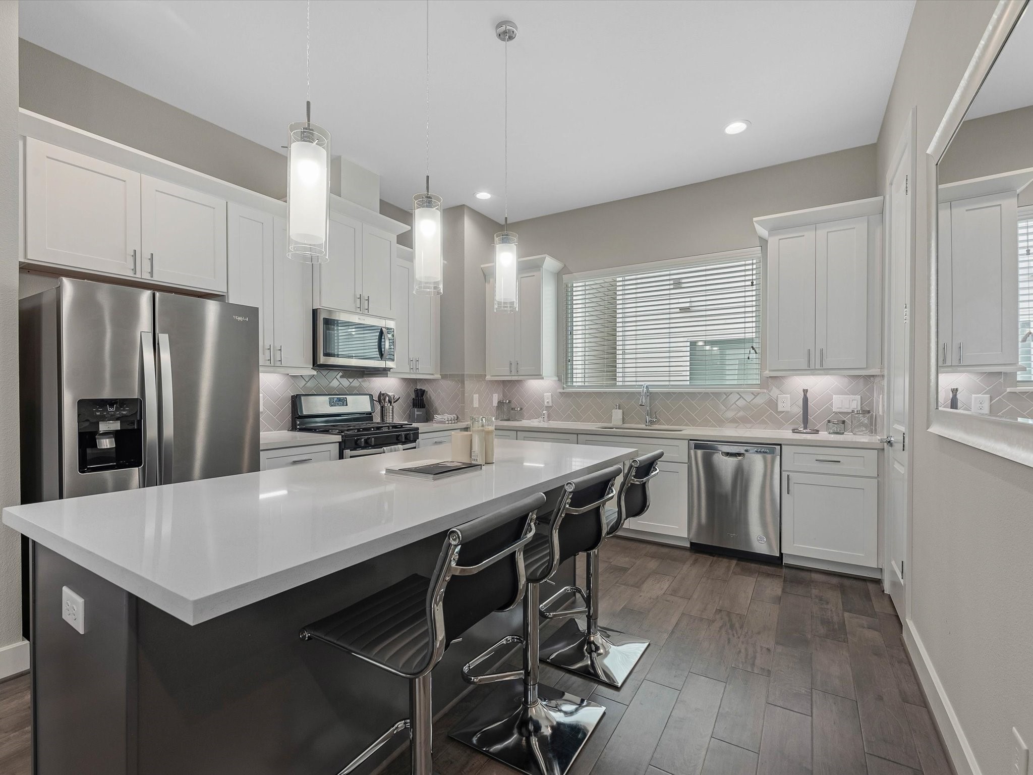 8311 Brecha Lane Houston, TX 77055 - Photo 6 of 19 a kitchen with granite countertop a center island stainless steel appliances a sink cabinets and wooden floor