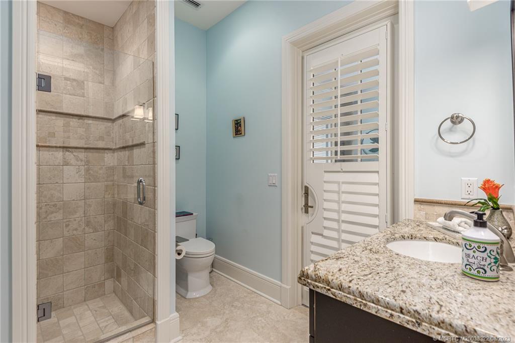 1455 Southeast Riverside Drive Stuart, FL 34996 - Photo 49 of 100 a bathroom with a granite countertop sink a toilet and shower