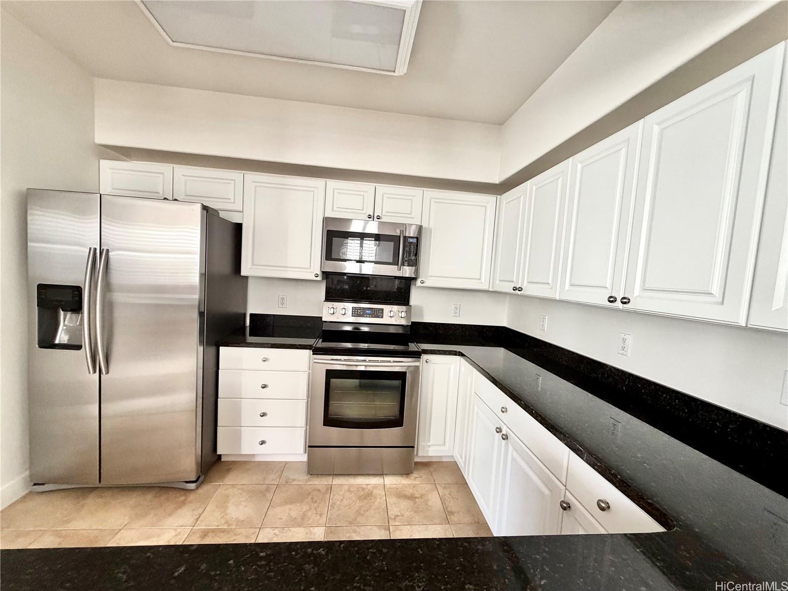 92-1037 Koio Drive, Unit M11 Kapolei, HI 96707 - Photo 5 of 11 a kitchen with stainless steel appliances cabinets and a counter top