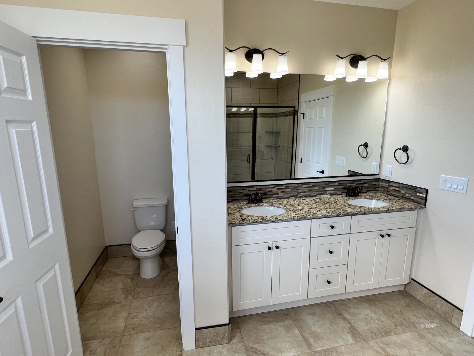 200 Ridgeway Drive Spring Creek, NV 89815 - Photo 29 of 34 a bathroom with a granite countertop sink a toilet and a mirror