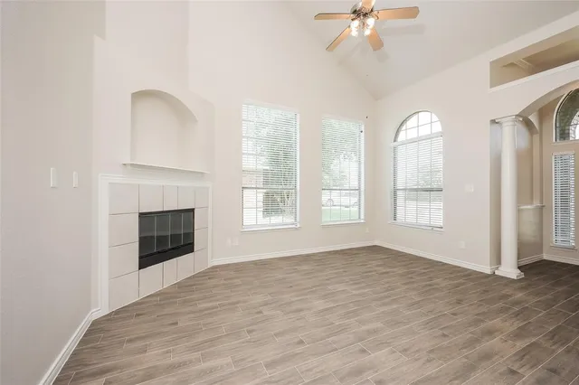 wooden floor fireplace and windows in an empty room