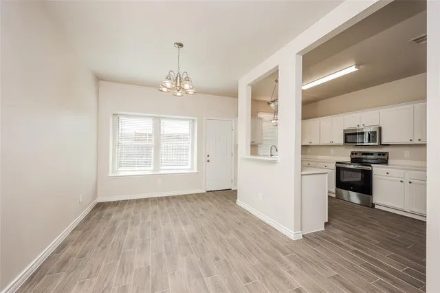 a view of kitchen with granite countertop cabinets and refrigerator