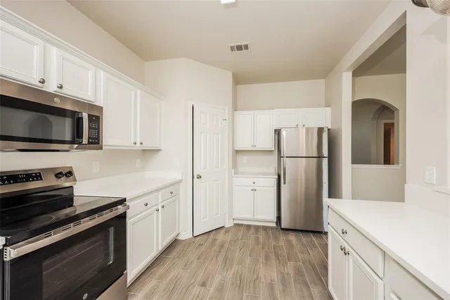 a kitchen with stainless steel appliances a refrigerator stove and microwave