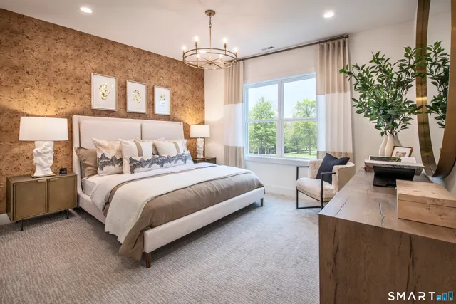 a bedroom with a large bed and a chandelier