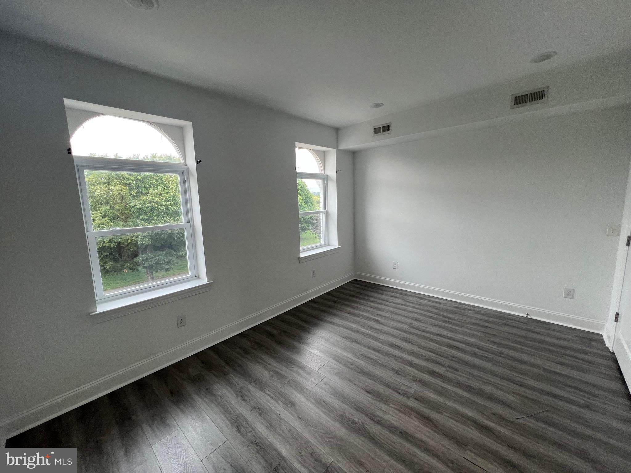 1829 North 33rd Street, Unit 4 Philadelphia, PA 19121 - Photo 7 of 10 a view of an empty room with wooden floor and a window