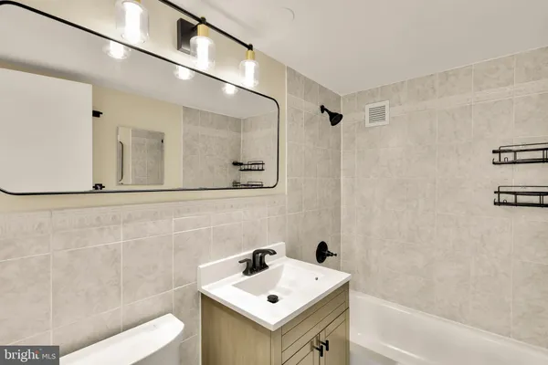 a bathroom with a sink mirror and a shower