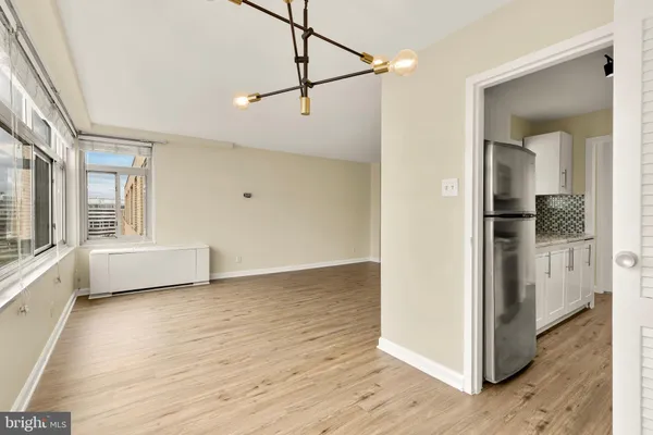 a view of a big room with wooden floor and windows