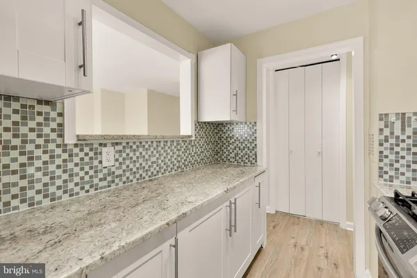 a bathroom with a granite countertop sink a toilet and a shower