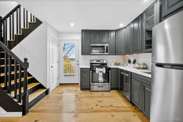 a kitchen with kitchen island granite countertop a refrigerator a stove top oven and a sink