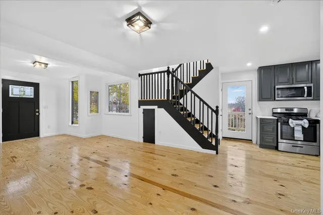 a view of a livingroom with wooden floor and staircase