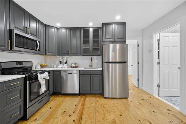 a kitchen with stainless steel appliances granite countertop a refrigerator stove and sink