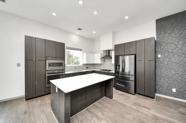 a kitchen with stainless steel appliances a refrigerator and a stove