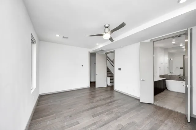 a view of a big room with wooden floor and windows