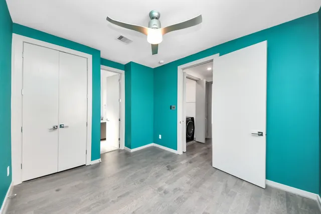 an empty room with closet and a chandelier fan