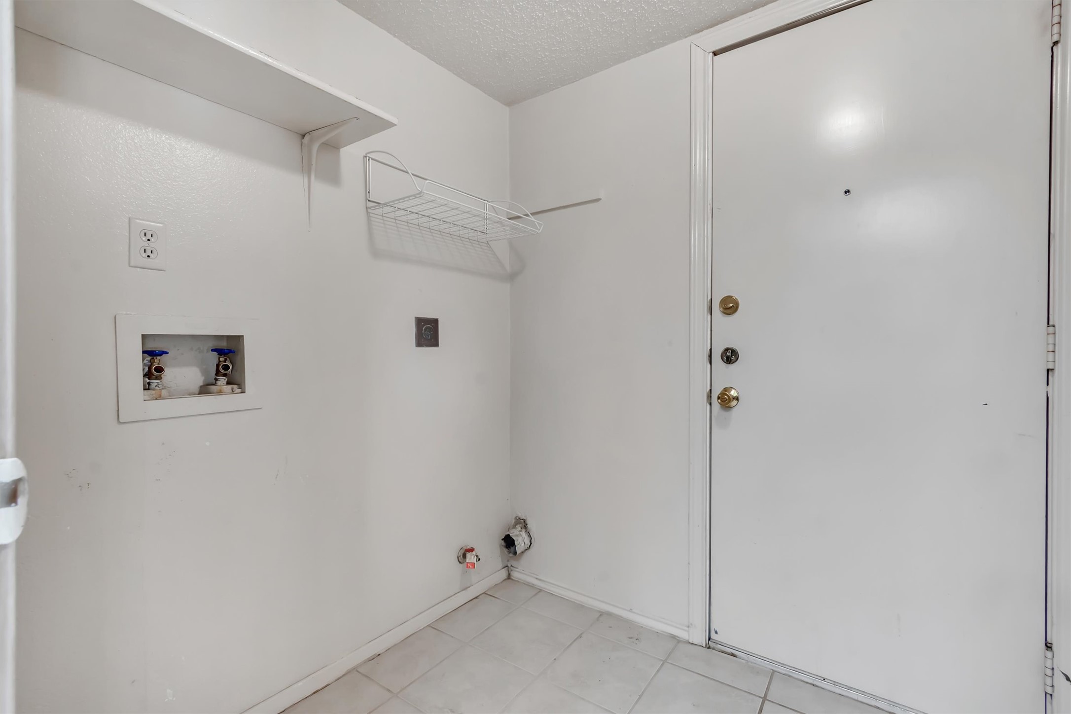7802 Topawa Cove, Unit B Austin, TX 78729 - Photo 8 of 32 A well-appointed laundry area offers convenient hookups and practical shelving.