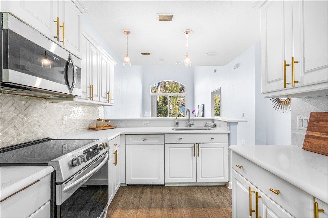 909 Bahia Mar Road Vero Beach, FL 32963 - Photo 2 of 36 a kitchen with stainless steel appliances a sink a stove and a wooden floors