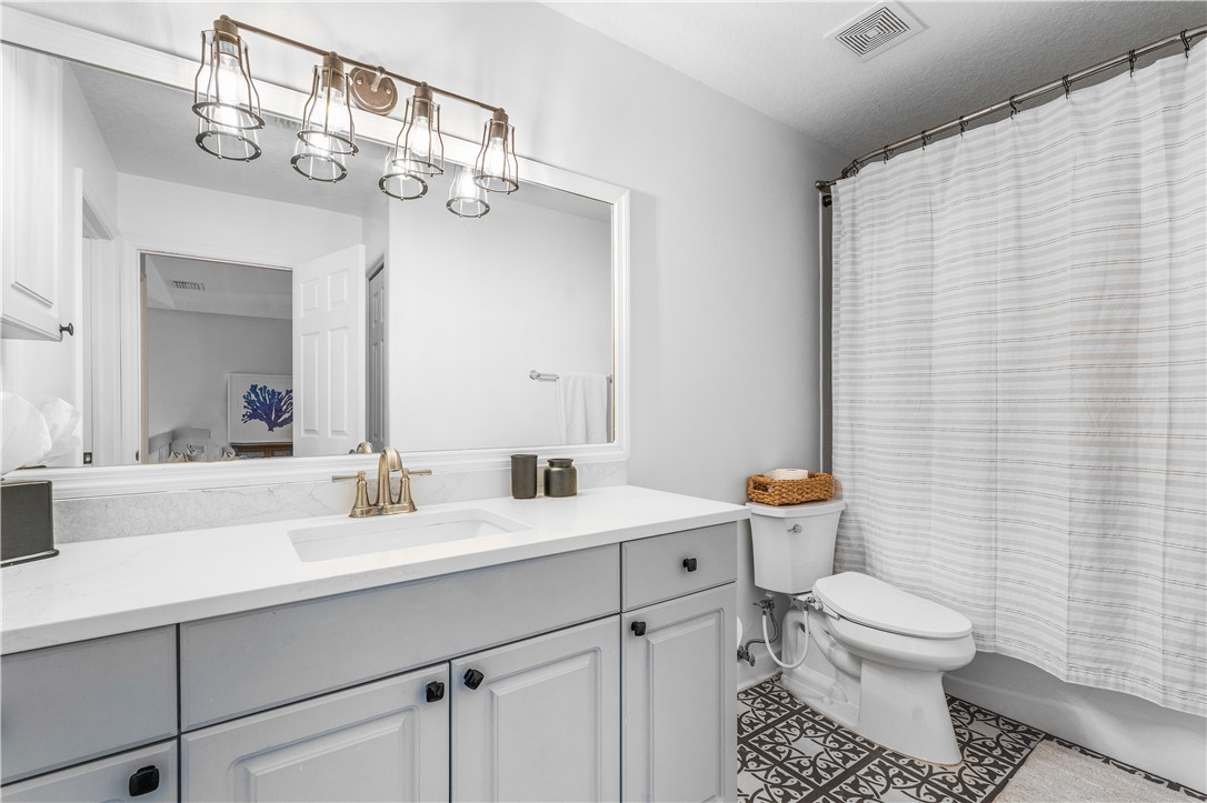 909 Bahia Mar Road Vero Beach, FL 32963 - Photo 26 of 36 a bathroom with a toilet a sink and mirror