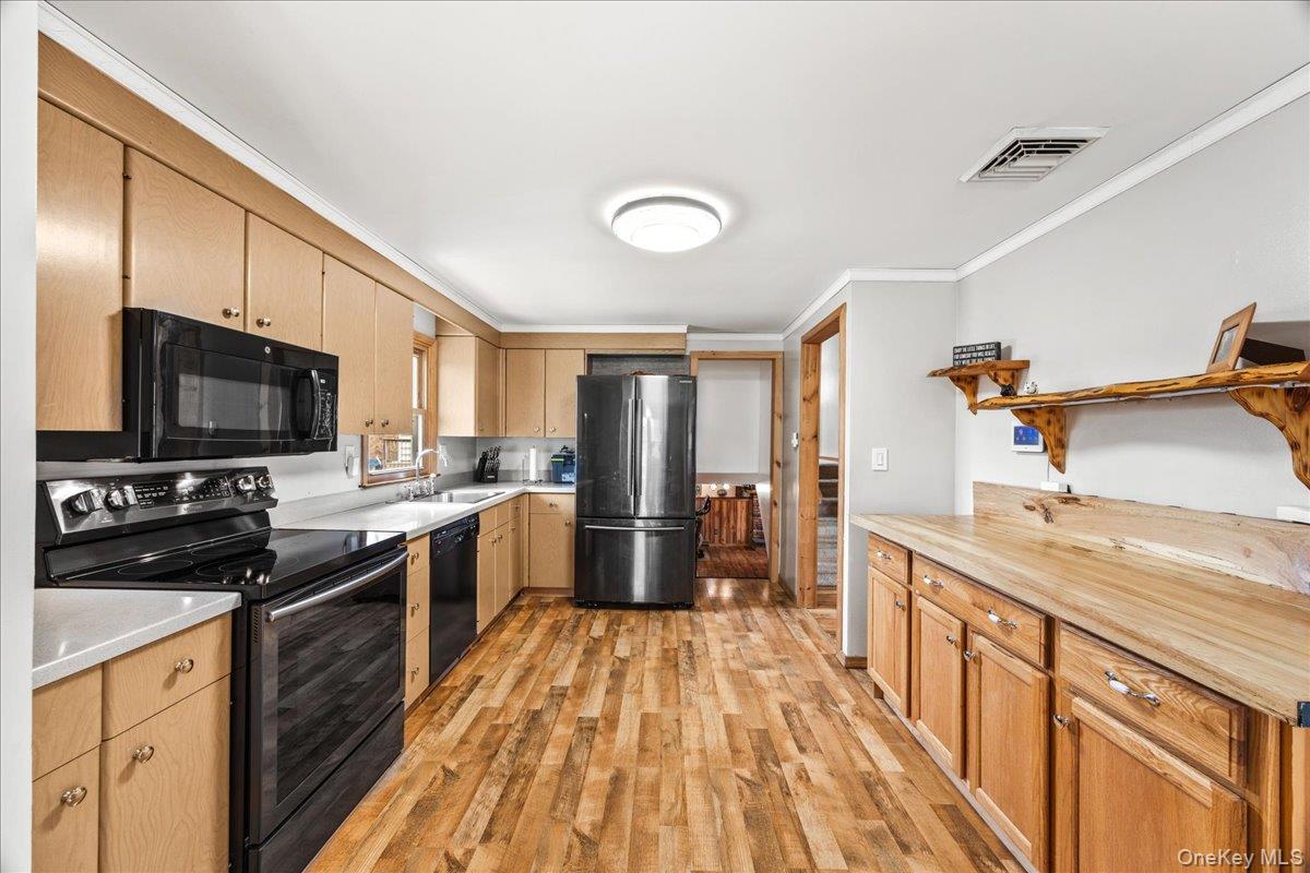 155 Mill Street Wallkill, NY 12589 - Photo 7 of 26 a large kitchen with a stove top oven a sink dishwasher a dining table and chairs with wooden floor