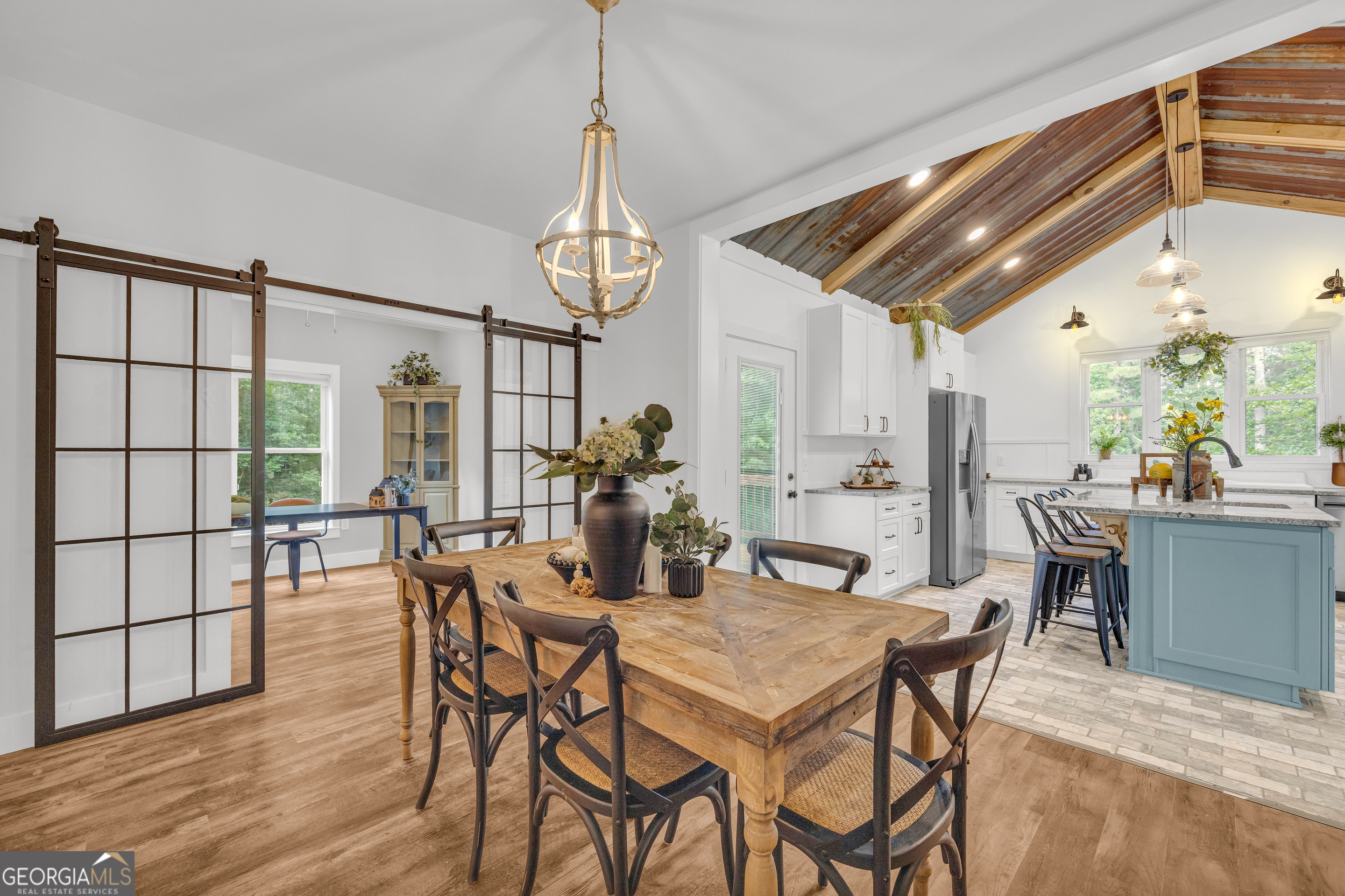 599 Double Branch Road Danielsville, GA 30633 - Photo 13 of 158 a view of a dining room and livingroom with furniture wooden floor a chandelier