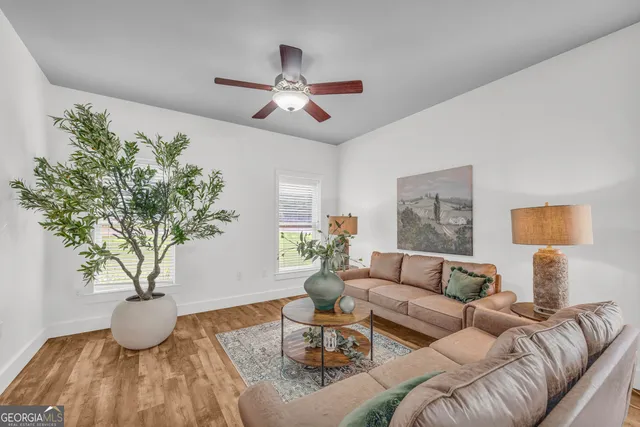a living room with furniture potted plant and a large window