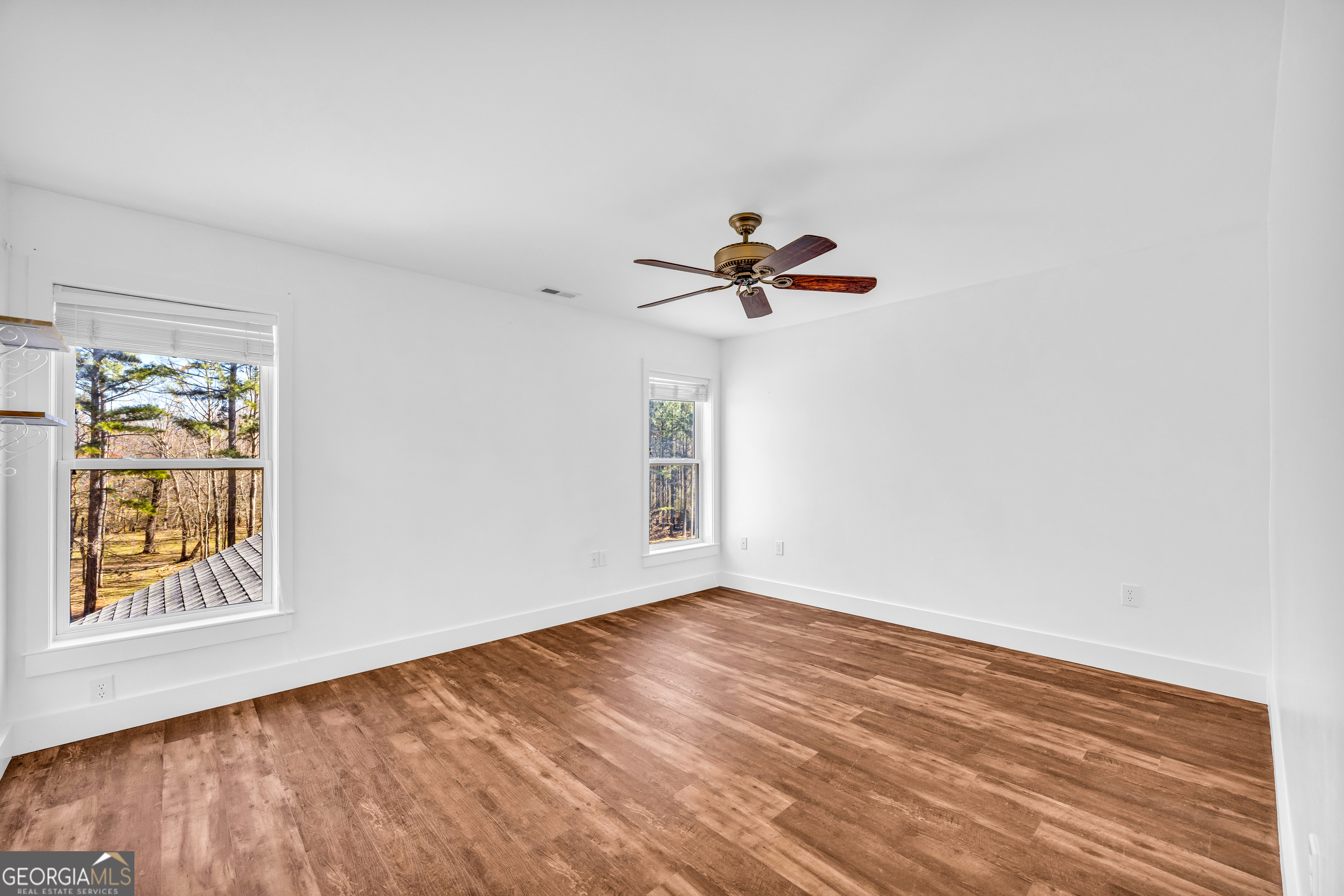 599 Double Branch Road Danielsville, GA 30633 - Photo 47 of 158 a view of empty room with wooden floor and fan