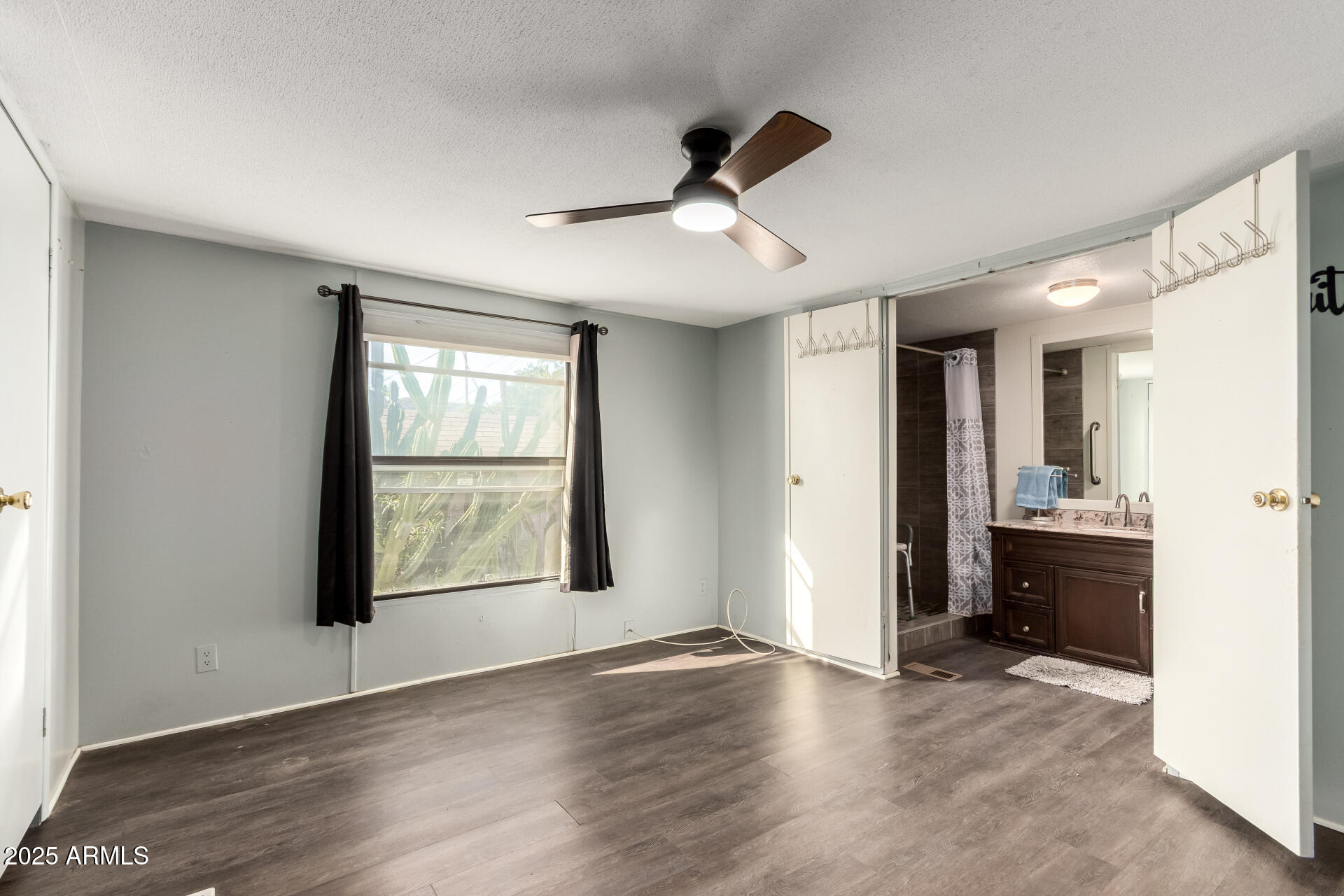 10401 North Cave Creek Road, Unit 93 Phoenix, AZ 85020 - Photo 11 of 28 a view of an empty room with a window and wooden floor
