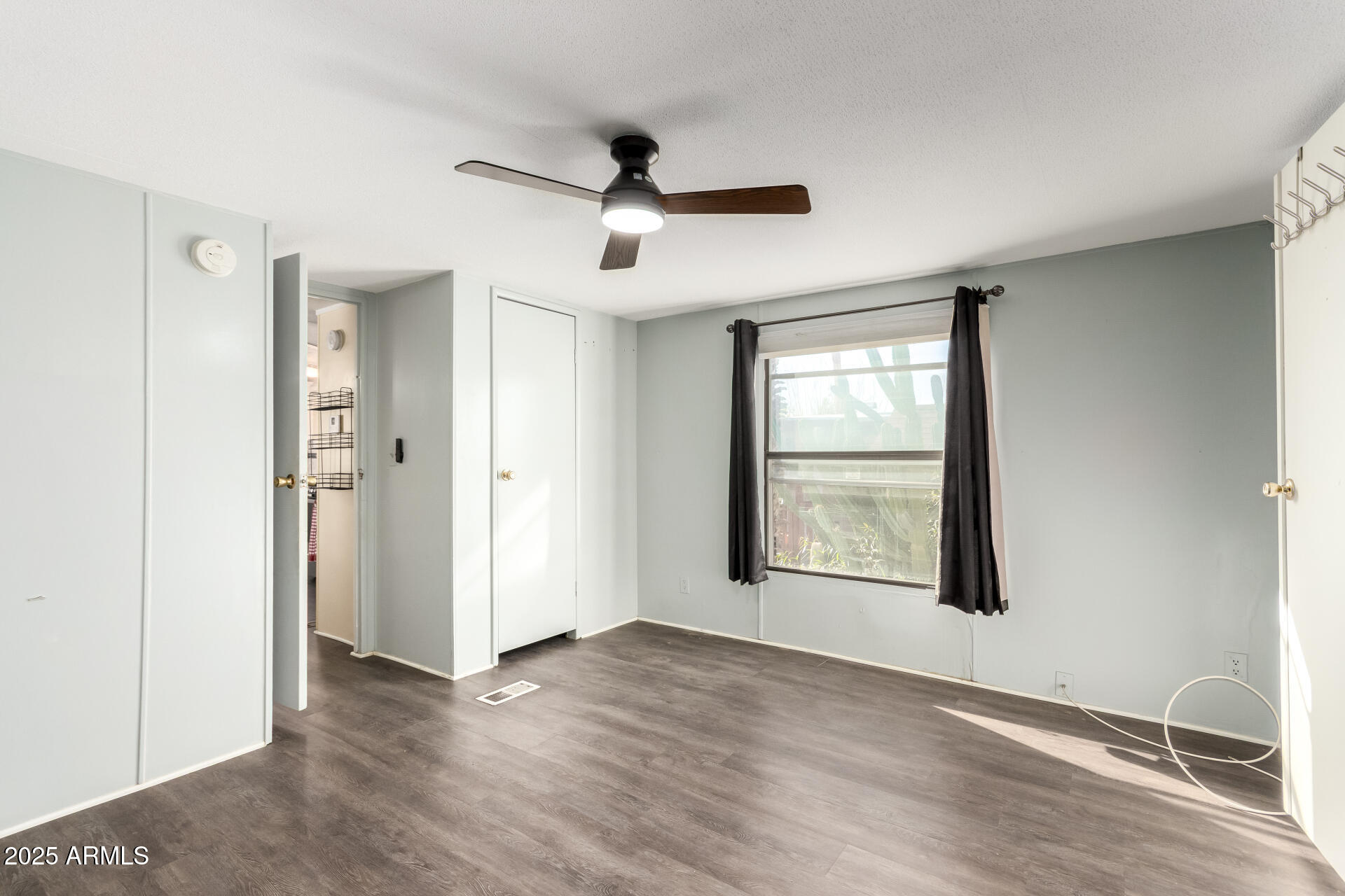 10401 North Cave Creek Road, Unit 93 Phoenix, AZ 85020 - Photo 12 of 28 a view of an empty room with a window and wooden floor