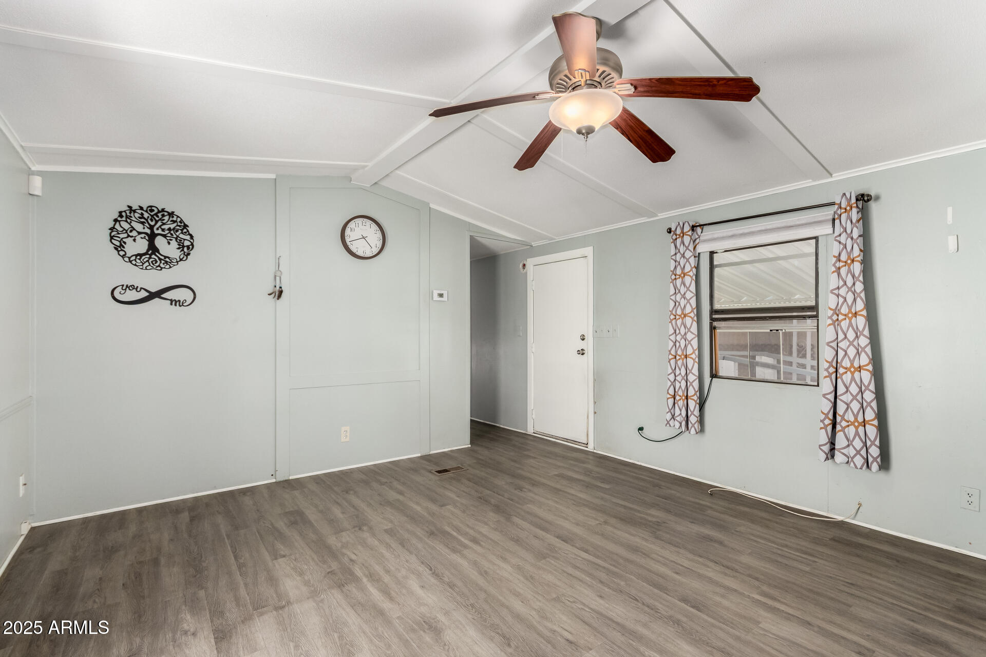 10401 North Cave Creek Road, Unit 93 Phoenix, AZ 85020 - Photo 4 of 28 an empty room with wooden floor and ceiling fan