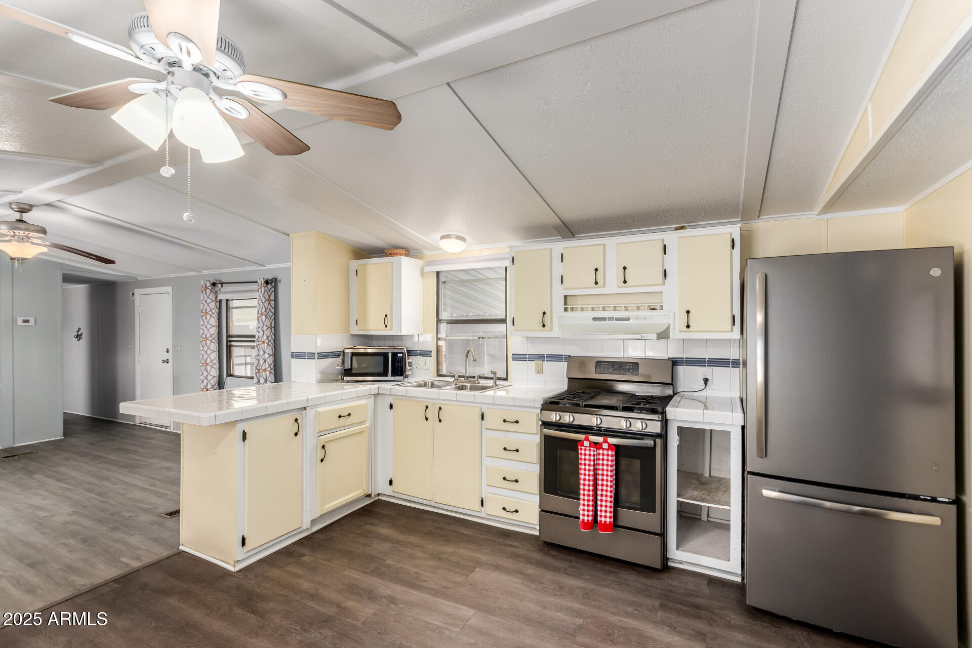 10401 North Cave Creek Road, Unit 93 Phoenix, AZ 85020 - Photo 6 of 28 a kitchen with a refrigerator a stove a microwave and island with wooden floor