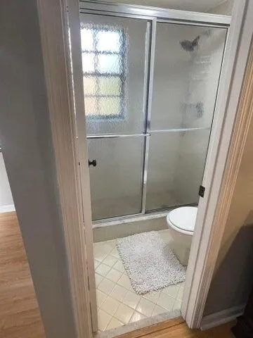a bathroom with a toilet and a shower