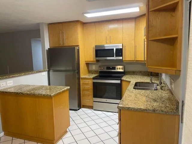 a kitchen with granite countertop a sink stainless steel appliances and cabinets