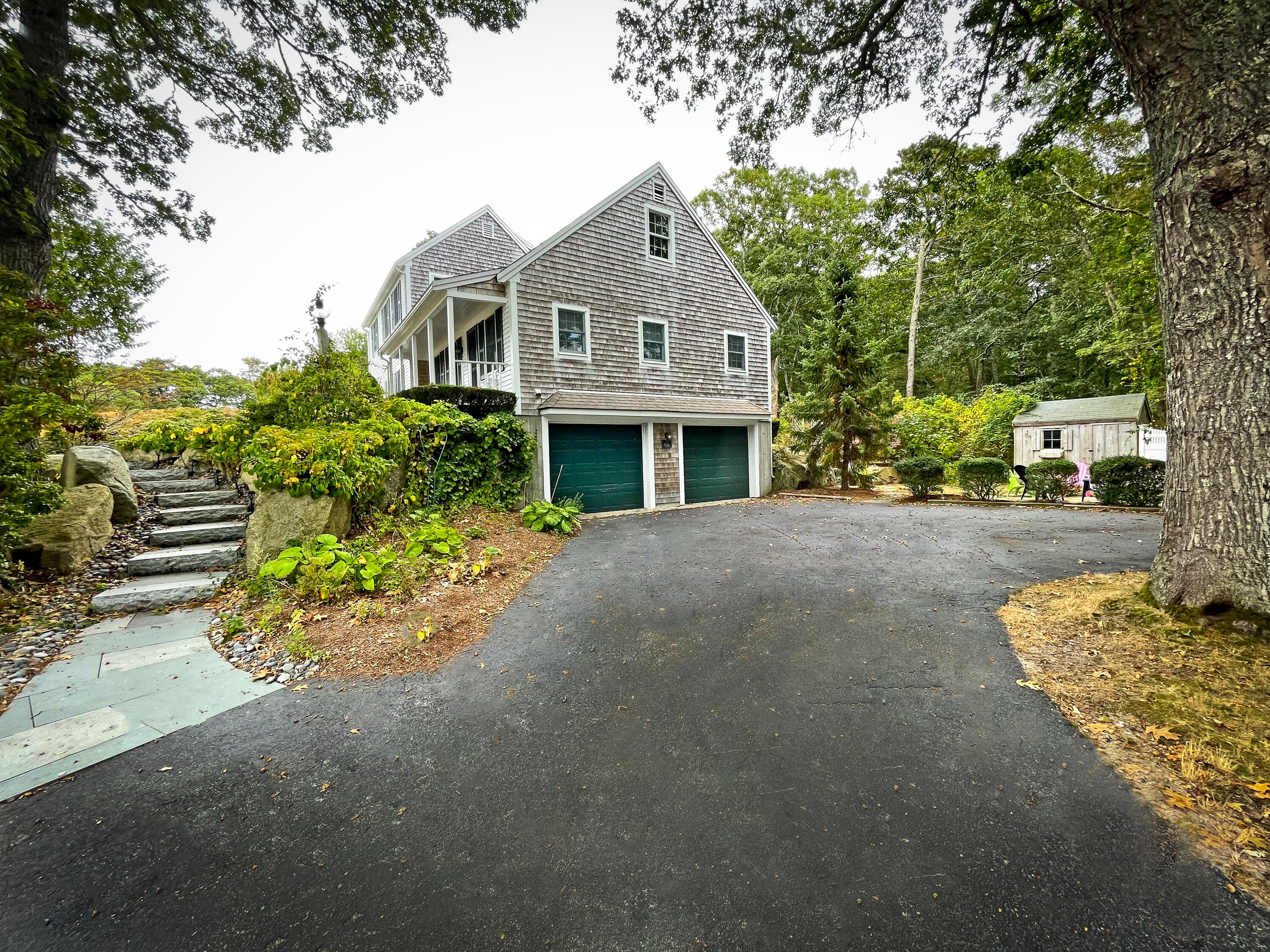 7 Captain Scott Road Harwich, MA 02645 - Photo 6 of 41 a view of a white house with a large tree and flower plants