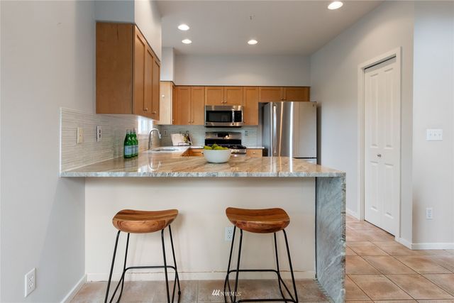 a kitchen with stainless steel appliances a refrigerator and a stove top oven