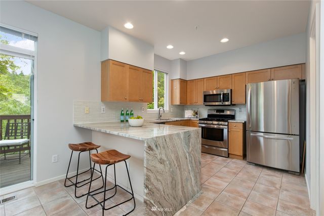 a kitchen with stainless steel appliances a refrigerator stove microwave and sink