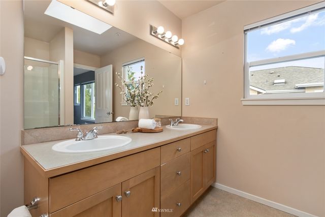 a bathroom with a granite countertop sink a large mirror and a shower