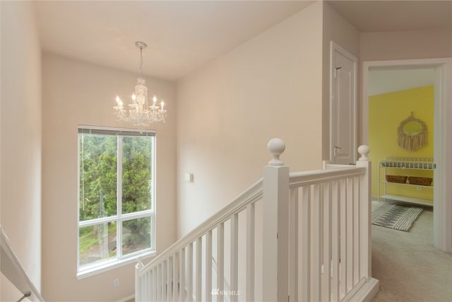a view of a hallway with windows and chandelier